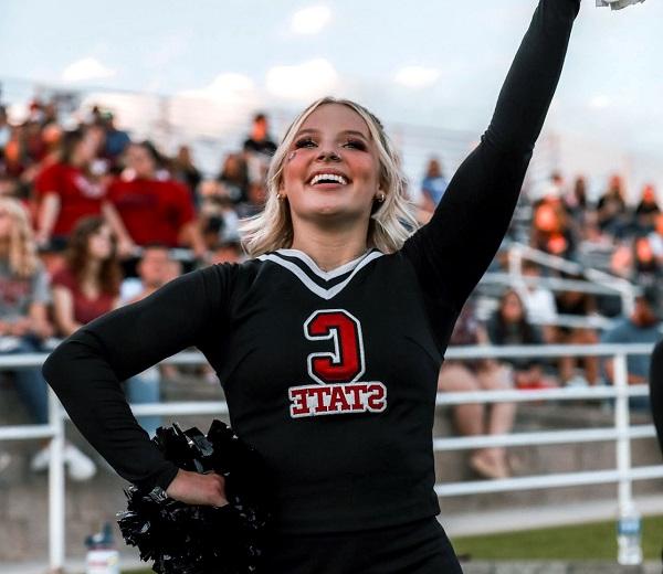 A cheerleader cheering at a CSC football game